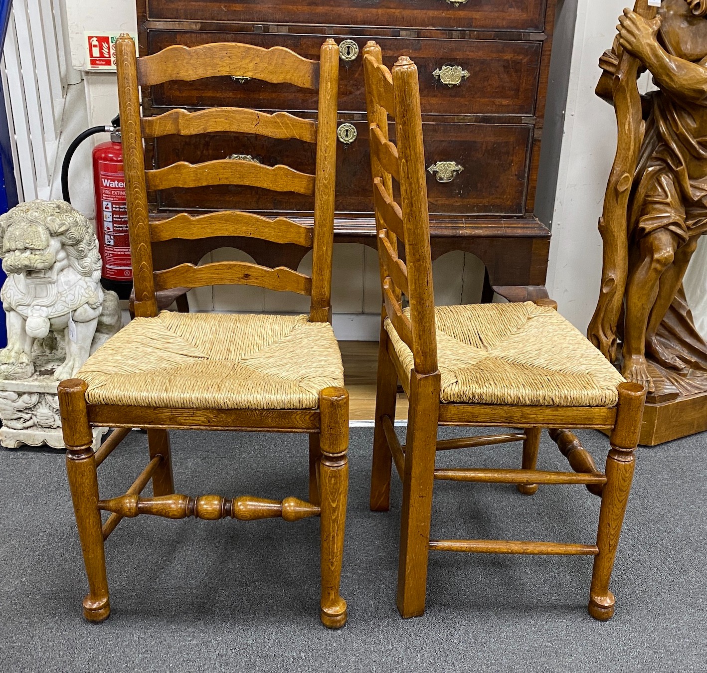 A good set of twelve reproduction Belvedere Furniture light oak ladderback dining chairs with drop in rush seats.